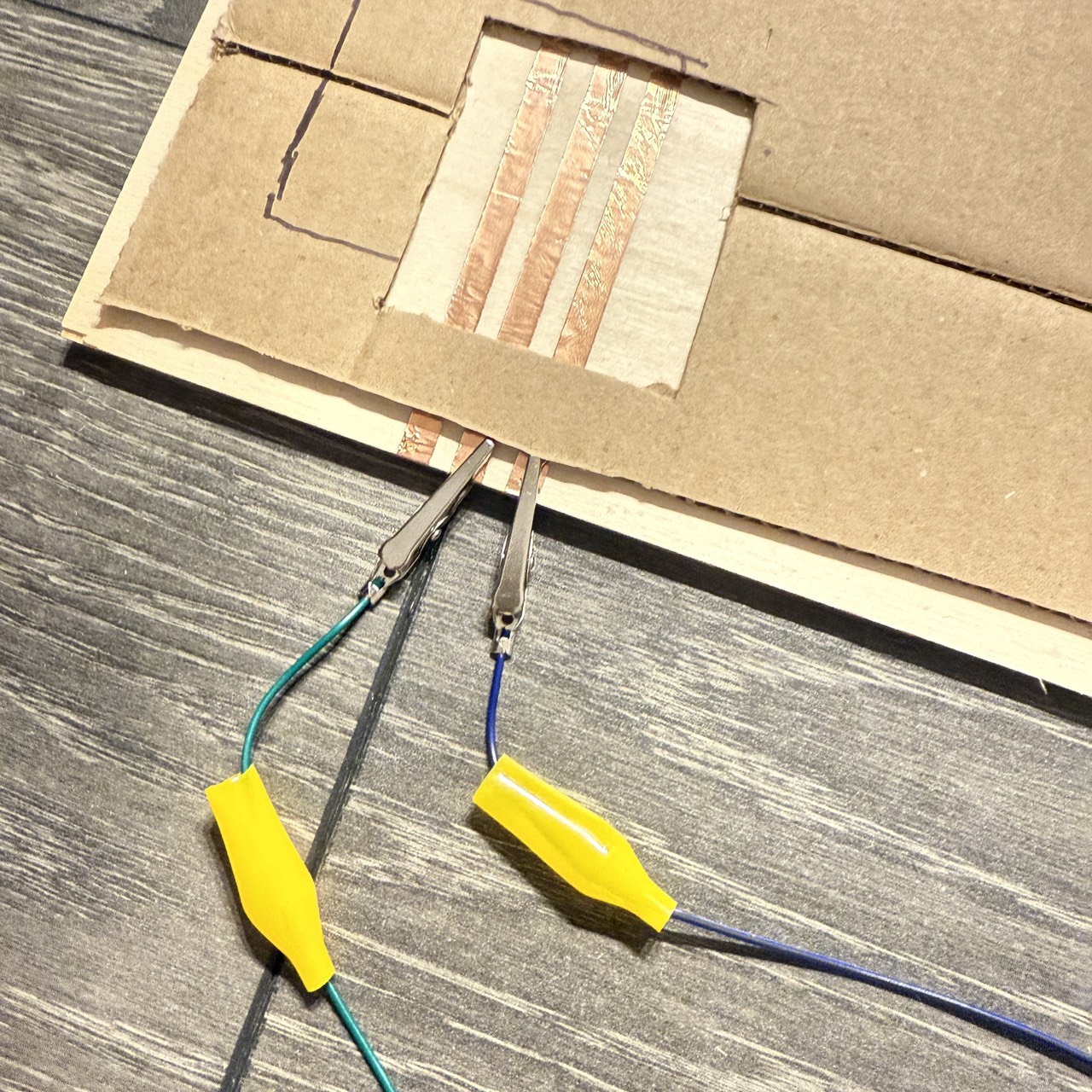 The close-up test confirms that copper tape conducts evenly when pressed at different angles. The unknown is whether small misalignment or peeling over time will interrupt the signal.